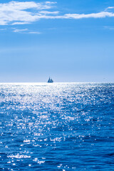 Sailboat in the open water under a sunny blue sky