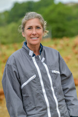 Portrait of a smiling female farmer standing in the middle of her chicken farm