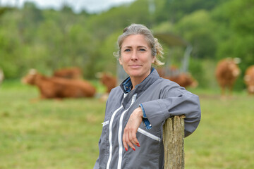 Portrait of a cattlewoman standing beside her cows