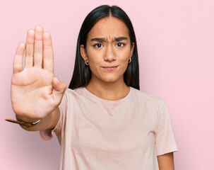 Young asian woman wearing casual clothes doing stop sing with palm of the hand. warning expression...