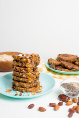oatmeal banana pancakes with chia seeds, almonds, prunes and dates, poured with honey and crushed nuts on a light background. diet breakfast healthy for the figure