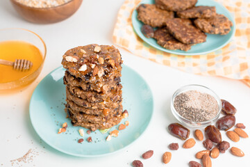 oatmeal banana pancakes with chia seeds, almonds, prunes and dates, poured with honey and crushed nuts on a light background. diet breakfast healthy for the figure