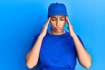 Beautiful brunette woman wearing delivery uniform suffering from headache desperate and stressed because pain and migraine. hands on head.