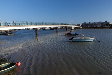 Obraz premium Two boats at anchor next to the Shoreham Adur Ferry Bridge which crosses the River Adur and link the main town to Shoreham by Sea.