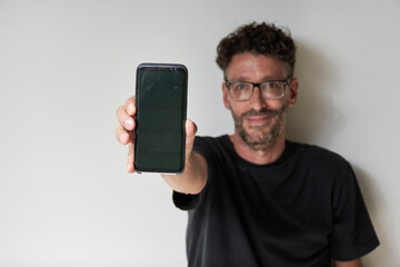 man in black shirt showing his smartphone on white background