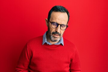 Middle age hispanic man wearing casual clothes and glasses with hand on stomach because indigestion, painful illness feeling unwell. ache concept.