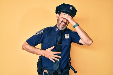 Middle age hispanic man wearing police uniform touching forehead for illness and fever, flu and cold, virus sick