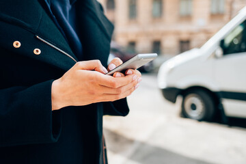 Woman wearing black coat using mobile phone