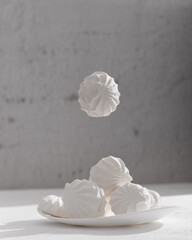 Levitating marshmallows. A delicate composition in a high key. Sweet meringue in a bowl