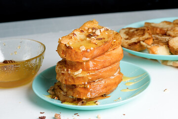 homemade French toast fried with honey and nuts on a blue plate on a dark background. soaked in milk egg mixture. healthy breakfast. close-up