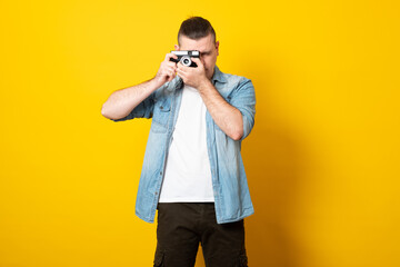 Young man takes pictures with a retro camera.