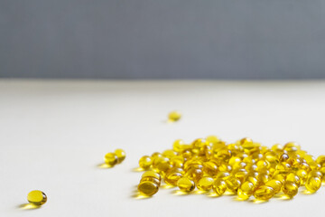 Yellow capsules are scattered on a light background.Soft focus.