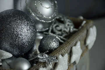 Silver and white decorations in a basket for Christmas.