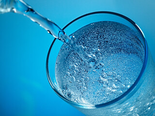 Mineral water is poured into a glass.