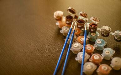 acrylic paints and brushes,
Painting by numbers, a set for painting, includes paints of different colors and brushes. Selective focus. Close up, self-isolation, home hobby, copy space for text