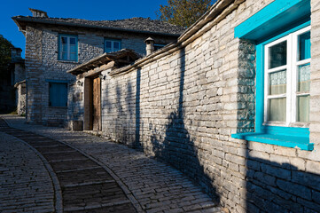 Stone houses of traditional architecture and cobble-stone narrow street in Papigo in Epirus, Greece