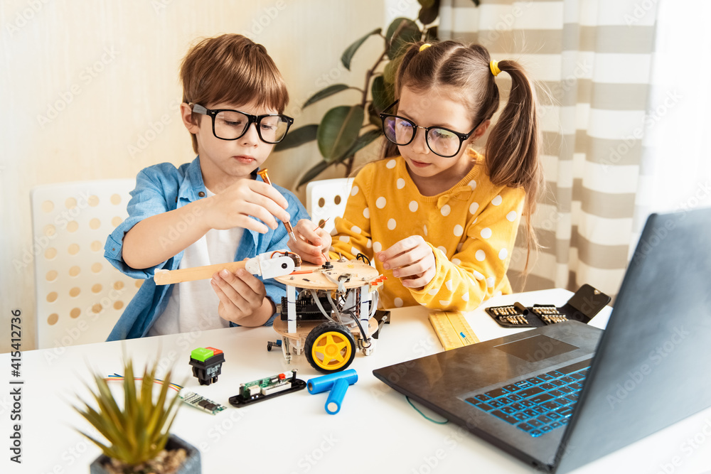 Wall mural happy kids programming and building science robotics project on his laptop at home during covid-19 p