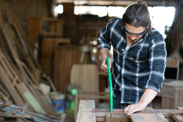 male carpenter using iron cutter blade for cutting wood in workshop