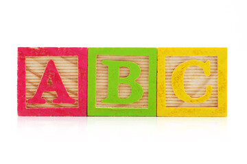 Front view of A B C wood blocks on white background with reflection