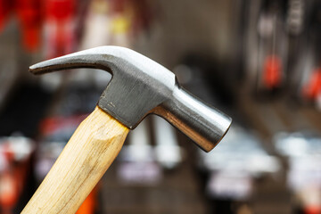 Metal hammer with a wooden handle. Fragment of a construction tool with a nail puller. Close-up