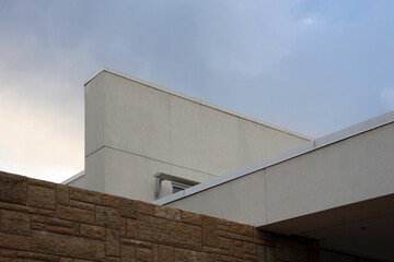 Obraz premium Low angle view of the upper part of a section of a modern building under a vivid autumn sky
