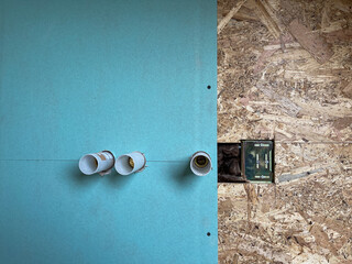 Installation of a new bathroom shower wall in a small home with plasterboard and fireboard, the internal and back parts of the faucet are installed