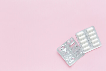 Blank packaging from tablets and blister of pills on pink background. Concept of course medication.