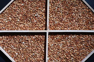A set of grain cereals. Rice, buckwheat and millet groats in a wooden tray. A grocery set of cereals. Import of grain.