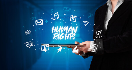 Young business person working on tablet and shows the inscription: HUMAN RIGHTS
