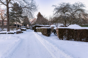 Naklejka premium Verschneiter Weg auf dem Friedhof beim Kloster Loccum im Winter Februar 2021