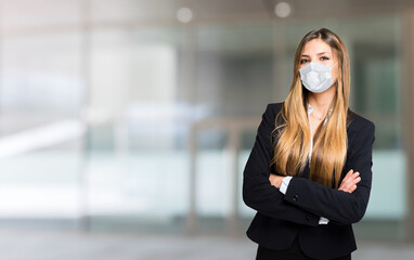 Portrait of a young masked businesswoman, covid coronavirus concept