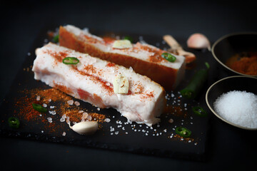 Lard with spices on a stone board. Salting lard. Gammoning.