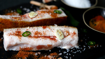 Lard with spices on a stone board. Salting lard. Gammoning.