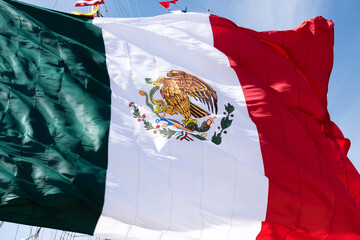 Close-up of the official Mexican flag blowing in the wind on the mast of a sailboat