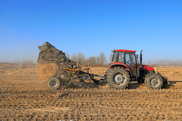 Obraz premium farmers use agricultural machinery to compress rice straw and bundle them on a farm, LUANNAN COUNTY, Hebei Province, China