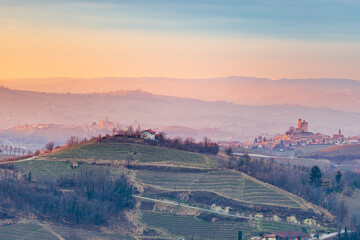 Italy Piedmont: wine yards unique landscape at sunset, Serralunga d'Alba medieval castle on hill top, La Morra and Castiglione Falletto villages, the Alps in the background, italian heritage