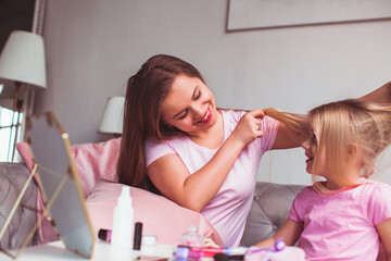 Mother and daughter enjoynig their reflection in the mirror
