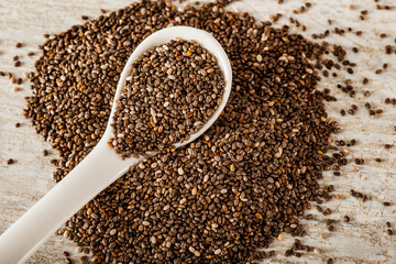 Chia seeds in glassware on a white wooden background with copy space. Chia seeds in a spoon on a white tree.