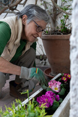 
Woman taking care of her garden, planting flowers and watering them