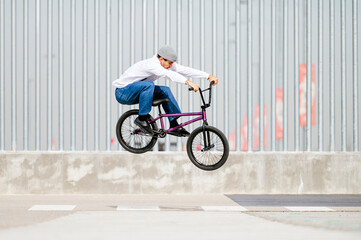 Young man performing tricks with a flatland bmx bike