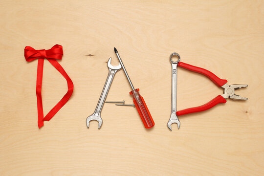 word dad from tools on wooden background