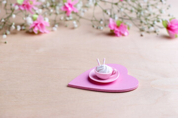 Obraz na płótnie Canvas Miniature cup and plate made of pink polymer clay with marshmallow and waffle tube. 