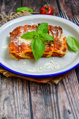 Cannelloni bolognese and parmesan cheese  on a wooden rustic  background.Home made italian meal

