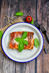 Cannelloni bolognese and parmesan cheese  on a wooden rustic  background.Home made italian meal
