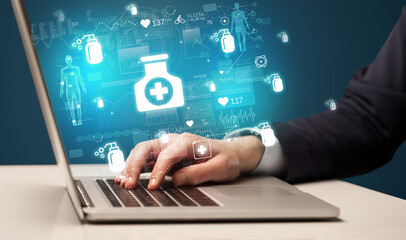 hand browsing on the internet for medical issues with medication icons coming out from the screen