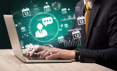 Business hand working on laptop with leader icons coming out from the screen, successful business concept