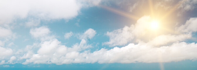 Fototapeta premium Strong sun, blue sky and clouds. Wide photo.