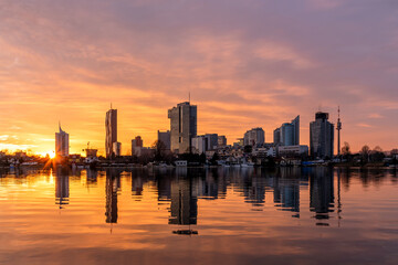 Skyline Wien im Abendrot zur goldenen Stunde mit Spiegelung im Wasser der Alten Donau 