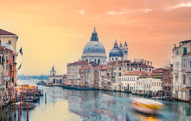 Fototapeta na wymiar Stunning view of the Venice skyline with the Grand Canal and Basilica Santa Maria Della Salute in the distance during a dramatic sunrise. Picture taken from Ponte Dell’ Accademia.