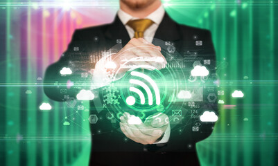 Businessman holding signal icon in his hands with multiple technology symbols around it